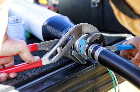 Close up of plumbers hands mounting new submersible water pump