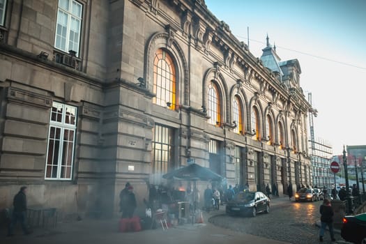 Porto, Portugal - November 30, 2018: Street atmosphere in front of the Porto train station where people walk one autumn evening