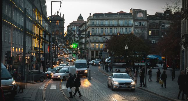 Porto, Portugal - November 30, 2018: atmosphere of a street in the historic city center where people walk on a autumn evening
