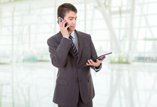 businessman using touch pad of tablet pc, on the phone, at the office