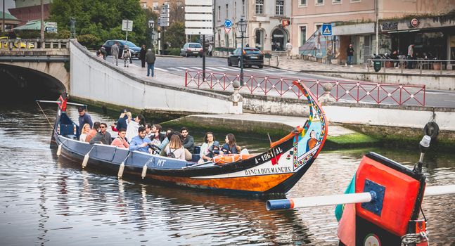 Aveiro, Portugal - May 7, 2018: Tourists walk on famous Moliceiros on a spring evening, traditional boats used to harvest seaweeds in the past