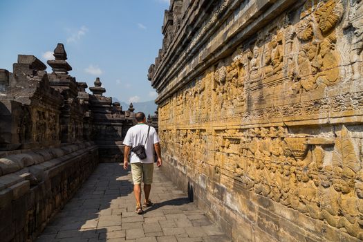 Man walking in the ancient Buddhist temple of Borobudur, in Magelang, Central Java, Indonesia