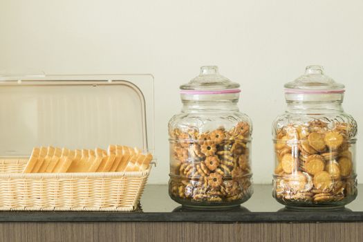 Bread in basket and Cookies and biscuits in glass jars on table