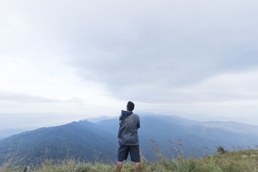 Young man standing on top of mountain