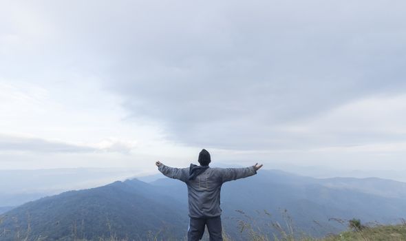 Man hand up on top of mountain,Travel concept
