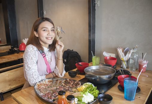 young asian woman enjoy eating Shabu-Shabu japanese hot pot