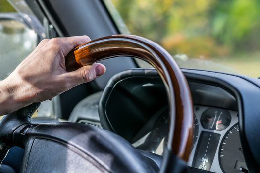 view of the hand of the people, the driver, holding the wheel of the car, close-up