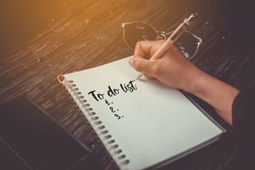 Top view of to do list on notebook paper with pen on table vintage style.