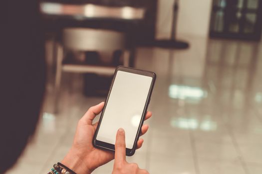 Woman hand use smartphone to do work business, social network, communication in public cafe work space area.