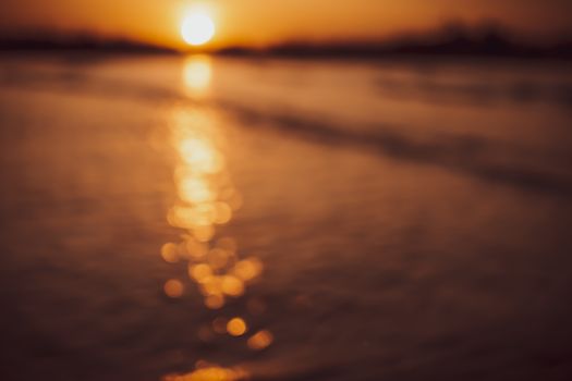 Blur beach with bokeh orange sunset theme color background.