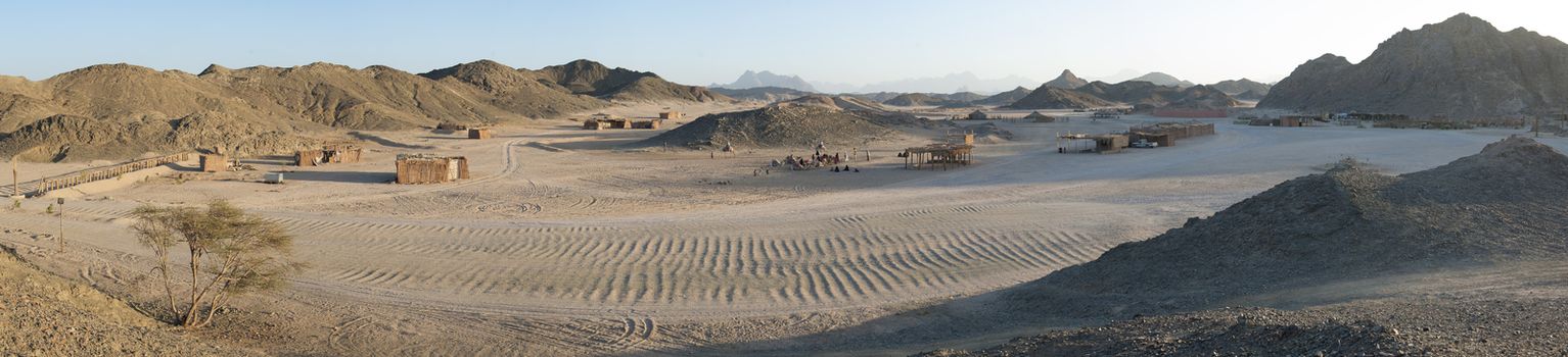 Panoramic view of a rocky desert landscape in africa with mountains and bedouin village