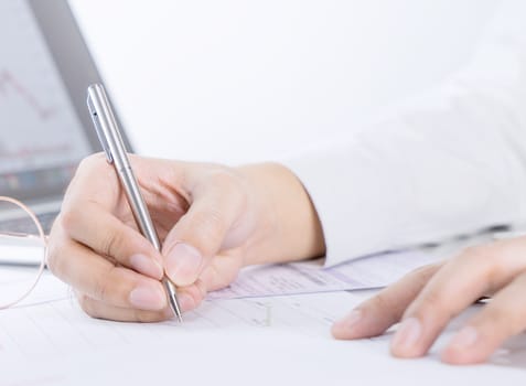 Business man is signing a financial document on office table