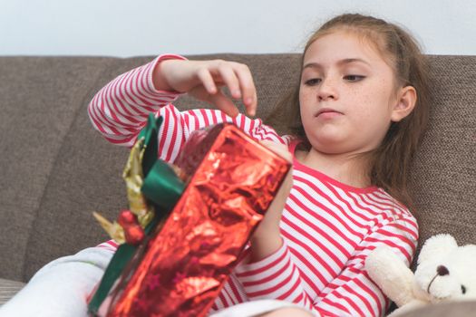 Little girl is open up Christmas present box