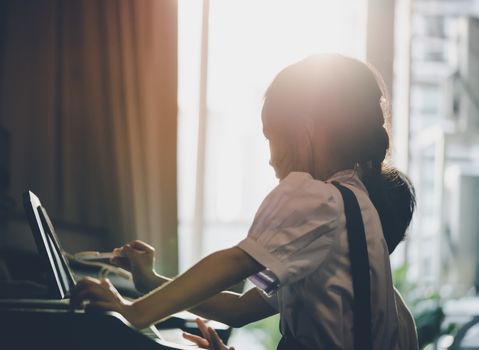 Little girl is playing with piano and Music Tablet at home