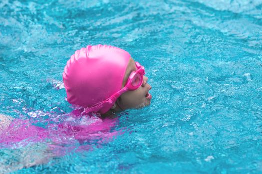 Little asian girl is swimming with glasses