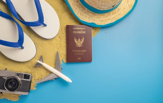 Beach travel accessories on sand and blue copy space