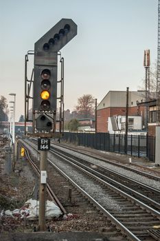 Hampshire, UK - February 11, 2012:  A single yellow light on a railway signal in Hampshire showing that a train driver must proceed with caution and be prepared to stop at the next signal.