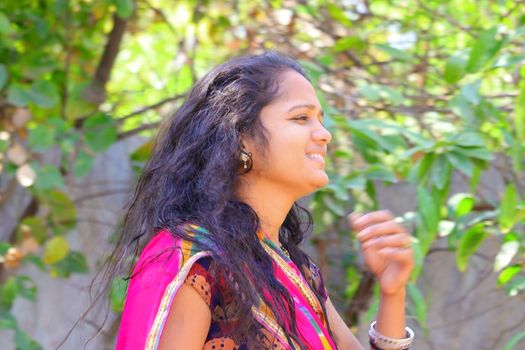 side view head shot of young happy girl walking in the garden