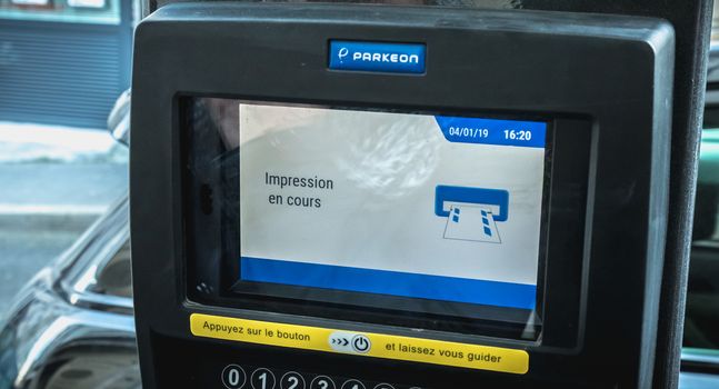 Sete, France - January 4, 2019: print in progress written in French on a parking ticket machine on a winter day