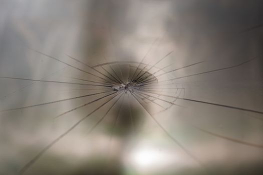 abstract background of broken tft lcd with localized radial cracks from one hit - close-up with selective focus and background blur