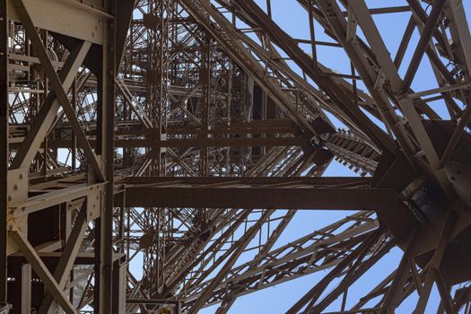 Inner up view of the Eiffel tower structure against a pur blue sky, Paris, France
