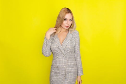 Attractive blonde woman in plaid jacket dress