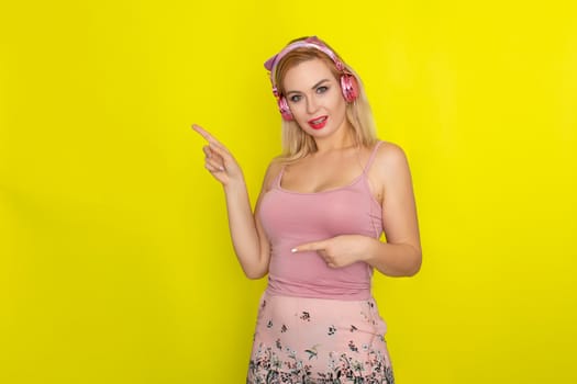 Blonde woman in pink summer clothing wearing pink headphones like kitten ears