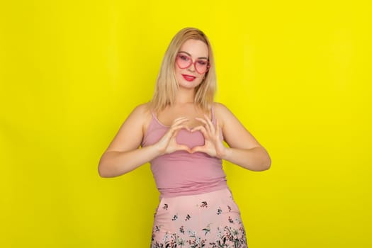 Blonde woman in summer street clothing wearing sunglasses like hearts