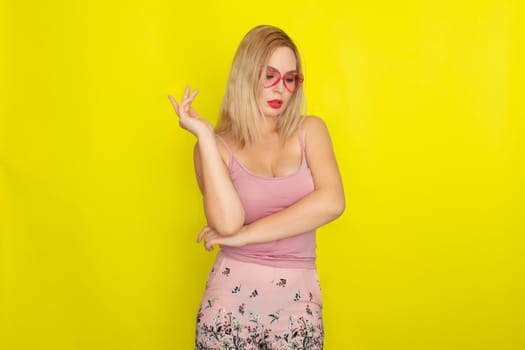 Blonde woman in summer street clothing wearing sunglasses like hearts