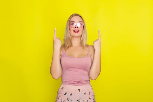 Blonde woman in summer street clothing wearing sunglasses like hearts