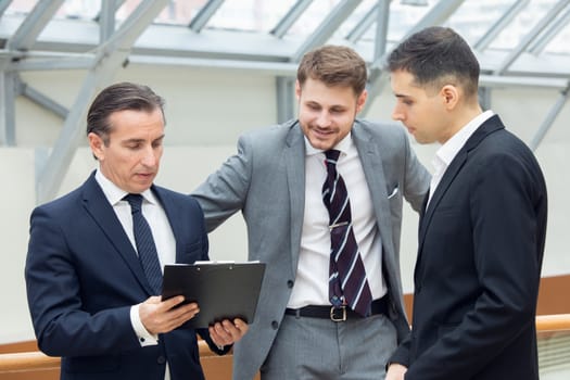 Business people having informal meeting in modern office discussing documents