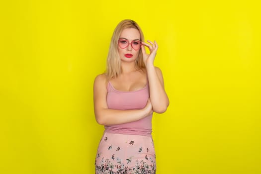 Blonde woman in summer street clothing wearing sunglasses like hearts