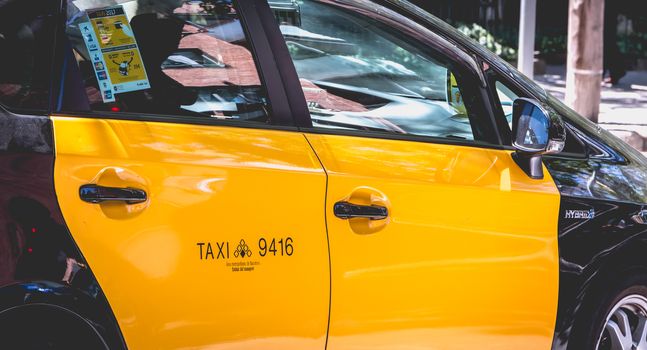 Barcelona, Spain - June 20, 2017: Closeup of a taxi car parked in the street on a summer day
