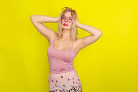 Blonde woman in summer street clothing wearing sunglasses like hearts