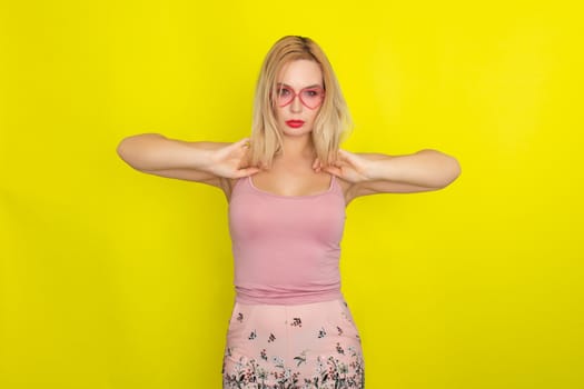 Blonde woman in summer street clothing wearing sunglasses like hearts