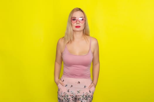 Blonde woman in summer street clothing wearing sunglasses like hearts