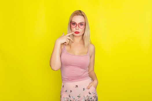 Blonde woman in summer street clothing wearing sunglasses like hearts