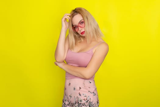 Blonde woman in summer street clothing wearing sunglasses like hearts