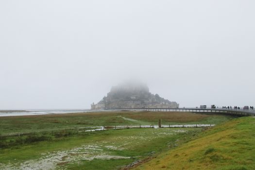 Panoramic views of Mont Saint Michel in a foggy morning. Stratified fog and suggestive view of the place