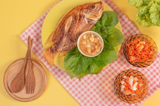 Fried fish dishes served with asian style sauce  , pickled vegetables and fresh lettuce