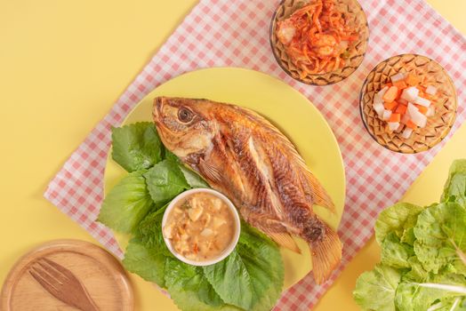 Fried fish dishes served with asian style sauce  , pickled vegetables and fresh lettuce