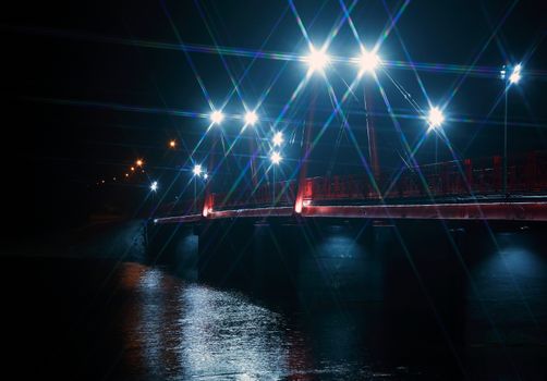 Night landscape with nice red bridge across river in winter at night