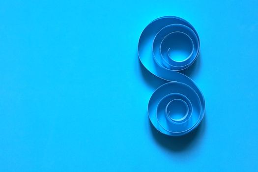 Pair of spirals made from paper on blue background