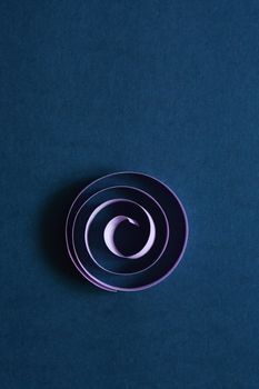 Purple spiral made from paper on dark blue background