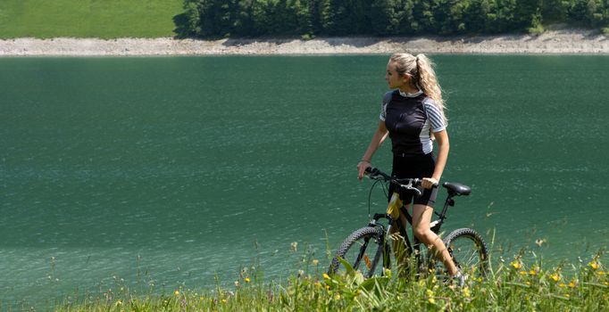 Life style woman with long blond hair on mountain bike in Swiss Alps