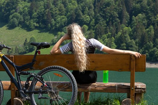 Life style woman with long blond hair on mountain bike in Swiss Alps