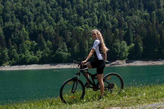 Life style woman with long blond hair on mountain bike in Swiss Alps