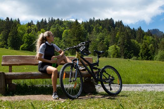 Life style woman with long blond hair on mountain bike in Swiss Alps