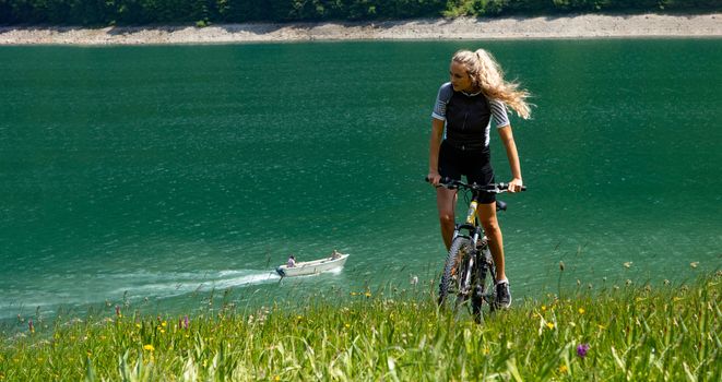 Life style woman with long blond hair on mountain bike in Swiss Alps