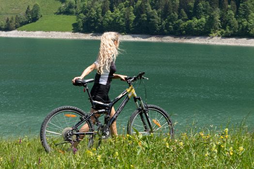 Life style woman with long blond hair on mountain bike in Swiss Alps